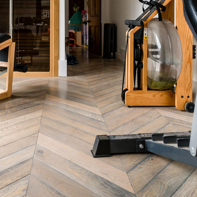 Grey chevron wood flooring in a home gym