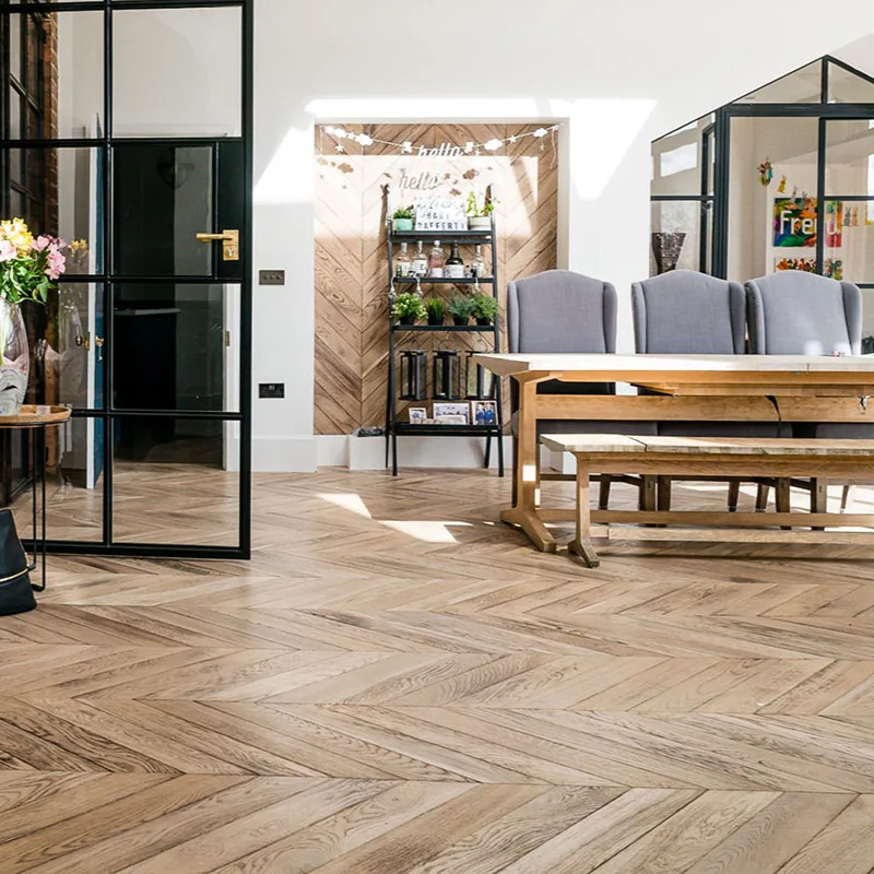 Modern chevron wood floors in a dining room.
